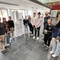 Architekt Peter Laimgruber und Schüler*innen der HLT Saalfelden betrachten gemeinsam die Ausstellung.