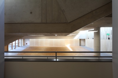 Bei der Sanierung wurde der Schulhof überdacht und damit ein großer, multifunktionaler Zentralraum geschaffen, der Foyer, Erschließung, Stiegenhaus, Pausenraum, Wartebereich, Nachmittagsbetreuung und Veranstaltungsraum in einem ist. Die prägende Waschbetonfassade des Altbaus wurde erhalten, woraus sich eine spannende Mischung von Alt und Neu ergibt.