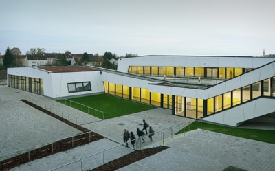 Bei der Erweiterung des Bundesschulzentrums Traun blieb der bestehende Schulbau in seiner Erscheinung erhalten und wurde durch neue Zubauten im Eingangsbereich ergänzt. Diese gegeneinander versetzen Bauten leiten mit großzügigen Öffnungen in die Schule. Es entstand eine spannende Lernlandschaft mit intensiven Beziehungen nach außen, wo eine große Freiarena für unterschiedliche Veranstaltungen Platz bietet.