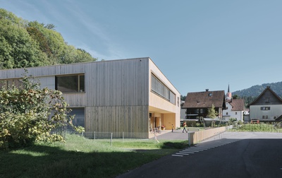 Der kompakte neue Kindergarten nimmt mit seiner Holzfassade Bezug zur Umgebung. Das offene Konzept bietet den Kindern und ihren Betreuer*innen vielfältige Entfaltungs- und Nutzungsoptionen. Die Architektur unterstützt die pädagogischen Intentionen und schafft mit ihrer Offenheit unterschiedliche Bereiche und Stimmungen.