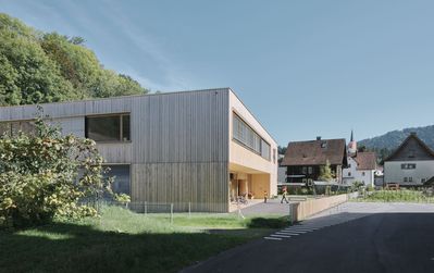 Der kompakte neue Kindergarten nimmt mit seiner Holzfassade Bezug zur Umgebung. Das offene Konzept bietet den Kindern und ihren Betreuer*innen vielfältige Entfaltungs- und Nutzungsoptionen. Die Architektur unterstützt die pädagogischen Intentionen und schafft mit ihrer Offenheit unterschiedliche Bereiche und Stimmungen.