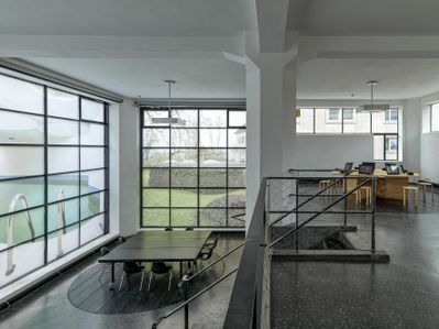 Blick in die Ausstellung "Widerstand und Wandel" im aut, Galerie und Lounge mit Fotos des 2018 zerstörten Grottenbad Flora (Josef Lackner, 1969 – 70) in den Fenstern