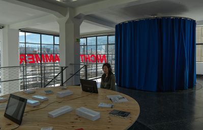 Blick in die Ausstellung „Legislating Architecture“ mit „Fernsehzimmer“ und Schriftzug „Nicht Jammern“